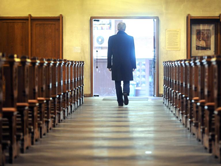 Ein Mann verlässt den Innenraum einer Kirche.