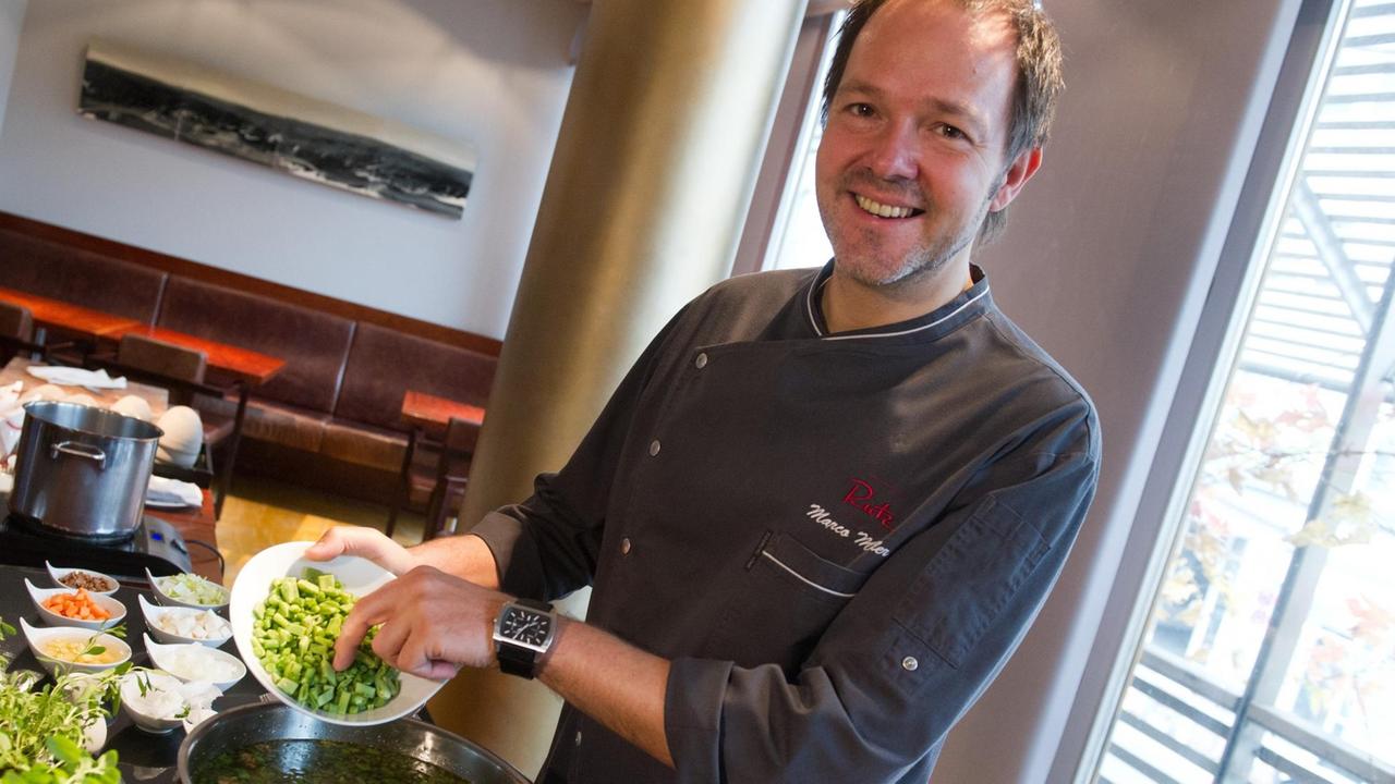 Das Foto zeigt den Sternekoch Marco Müller in seinem Restaurant "Rutz", wie er gerade eine Suppe kocht.