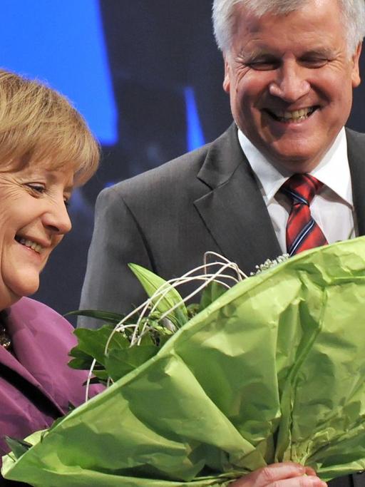 Die Bundeskanzlerin Angela Merkel (CDU) erhält am Freitag (29.10.2010) in München (Oberbayern) auf dem Parteitag der CSU nach ihrer Grußrede einen Blumenstrauß vom CSU-Parteivorsitzenden Horst Seehofer.