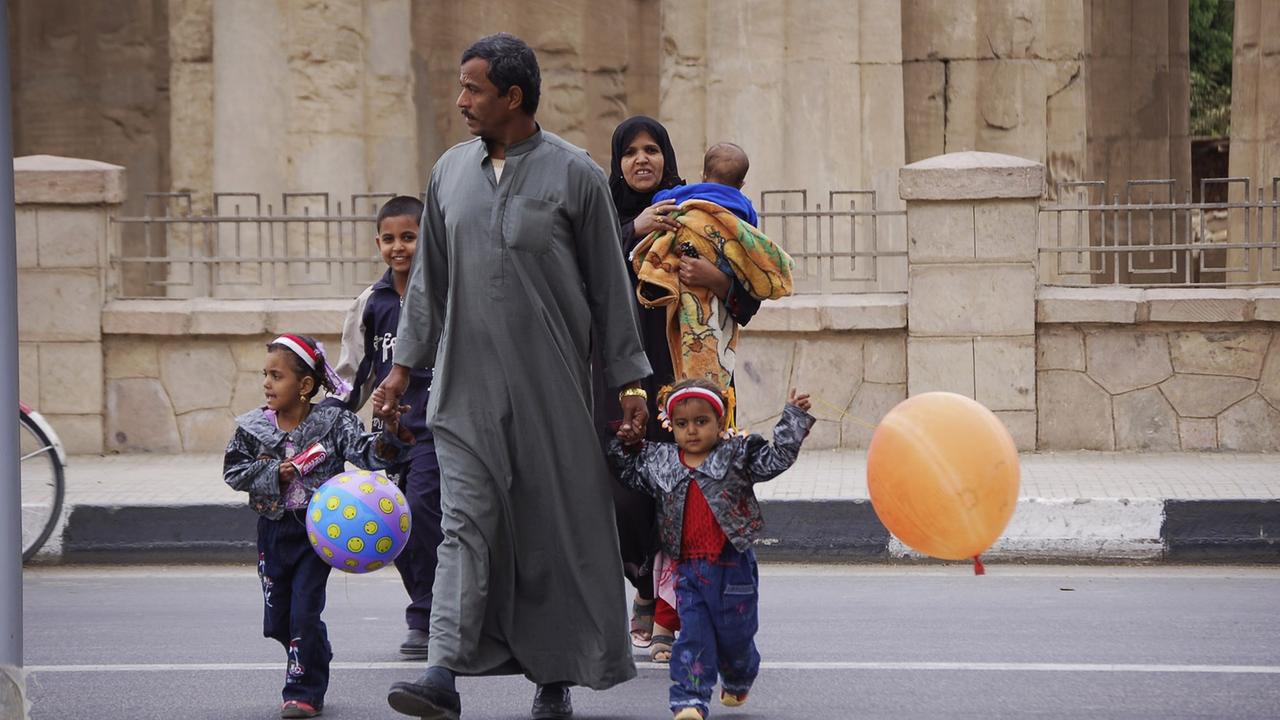 Eine ägyptische Familie überquert die Uferstraße am Luxor-Tempel in Luxor