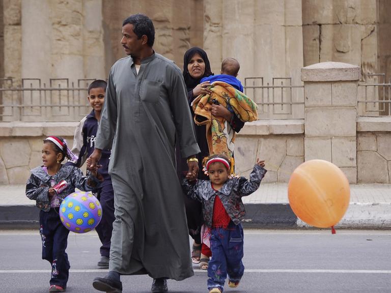 Eine ägyptische Familie überquert die Uferstraße am Luxor-Tempel in Luxor