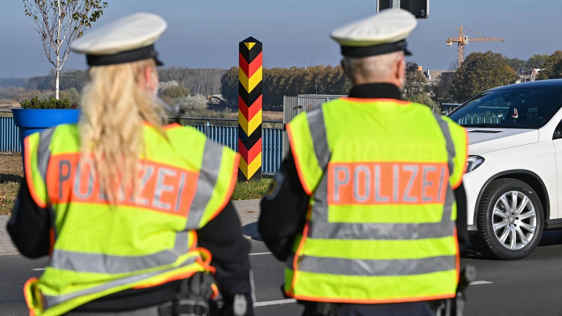 Eine Beamtin und ein Beamter der Bundespolizei stehen am deutsch-polnischen Grenzübergang. Eine Beamtin und ein Beamter der Bundespolizei stehen am deutsch-polnischen Grenzübergang.