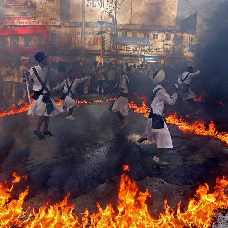 Sikh-Gläubige tanzen wegen Geburtstagsfeierlichkeiten für den ersten Sikh-Guru Nanak Dev durchs Feuer.