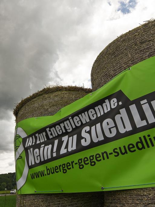 Auf Heuballen prangt am 20.05.2015 an einer Straße bei Fritzlar (Hessen) ein Transparent der Gegner der Stromtrasse Suedlink.