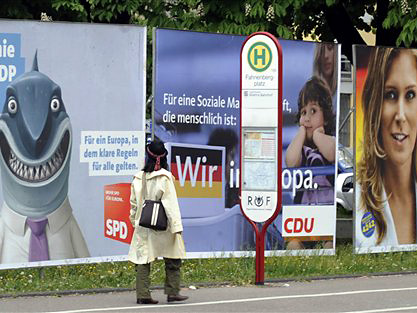 Eine Passantin geht in Freiburg an Wahlplakaten zur Europawahl vorbei.