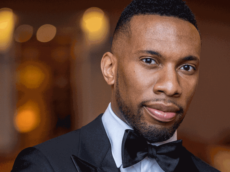 Der Dirigent Roderick Cox blickt in Konzertkleidung in die Kamera.