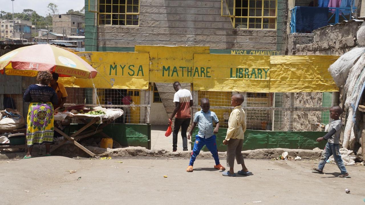 Kinder spielen vor dem Eingang der MYSA Mathare Library in einem Slum in Nairobi