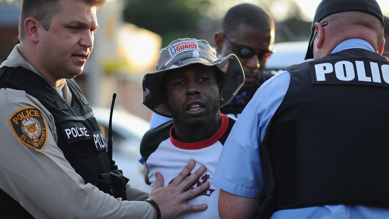In der US-Kleinstadt Ferguson nimmt die Polizei einen schwarzen Demonstranten fest.