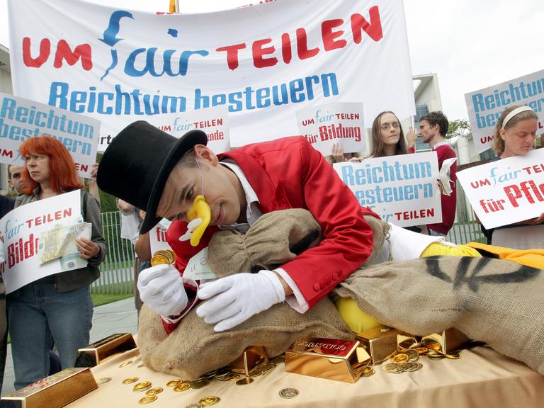 "Umfairteilen": Menschen demonstrieren am Freitag (03.08.2012) vor dem Bundeskanzleramt in Berlin für eine stärkere Besteuerung von Reichtum.