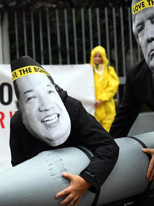 Aktivisten der Internationalen Kampagne zur Abschaffung von Atomwaffen (ICAN) protestieren vor der nordkoreanischen Botschaft in Berlin mit Masken des nordkoreanischen Machthabers Jong-un (l) und des US-Präsidenten Trump gegen den Konflikt zwischen Nordkorea und den USA.