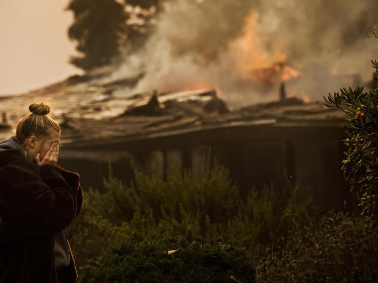 Eine 16-jährige Bewohnerin von Island View Drive wischt sich die Tränen ab, als sie das Haus ihrer Familie in Ventura, Kalifornien, sieht, das durch den Brand des Thomas-Feuers zerstört wurde.