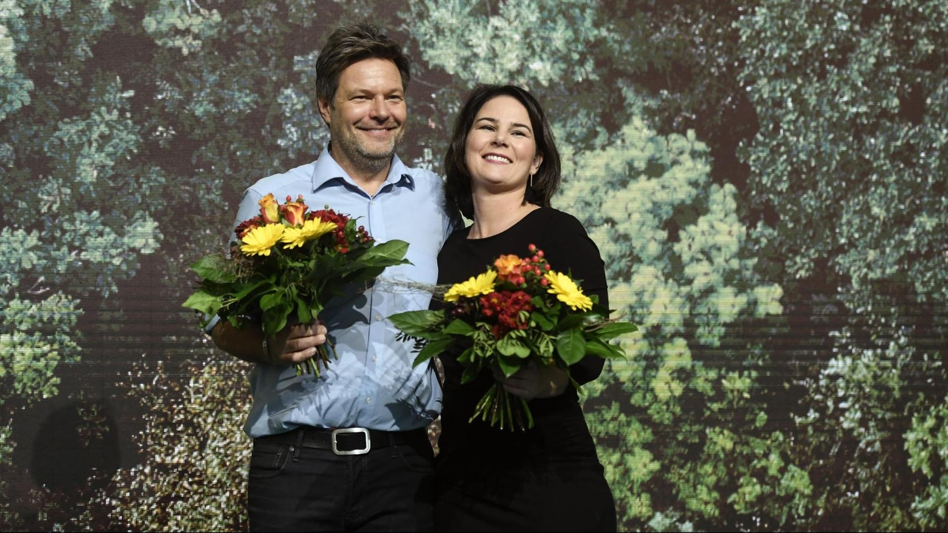 Die Grünen-Vorsitzenden Habeck und Baerbock mit Blumensträußen nach ihrer Wiederwahl.