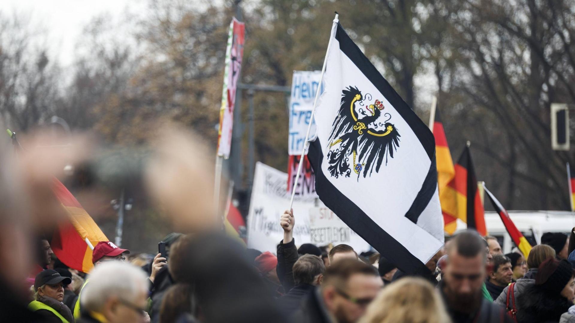 Kundgebung gegen den UN-Migrationspakt am 1.12.2018 in Berlin: Die Demonstranten schwenken Deutschlandfahnen und Transparente.