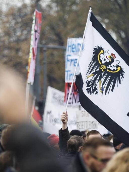 Kundgebung gegen den UN-Migrationspakt am 1.12.2018 in Berlin: Die Demonstranten schwenken Deutschlandfahnen und Transparente.