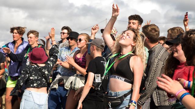 Junge Leute tanzen und hören Musik auf einem Festival.