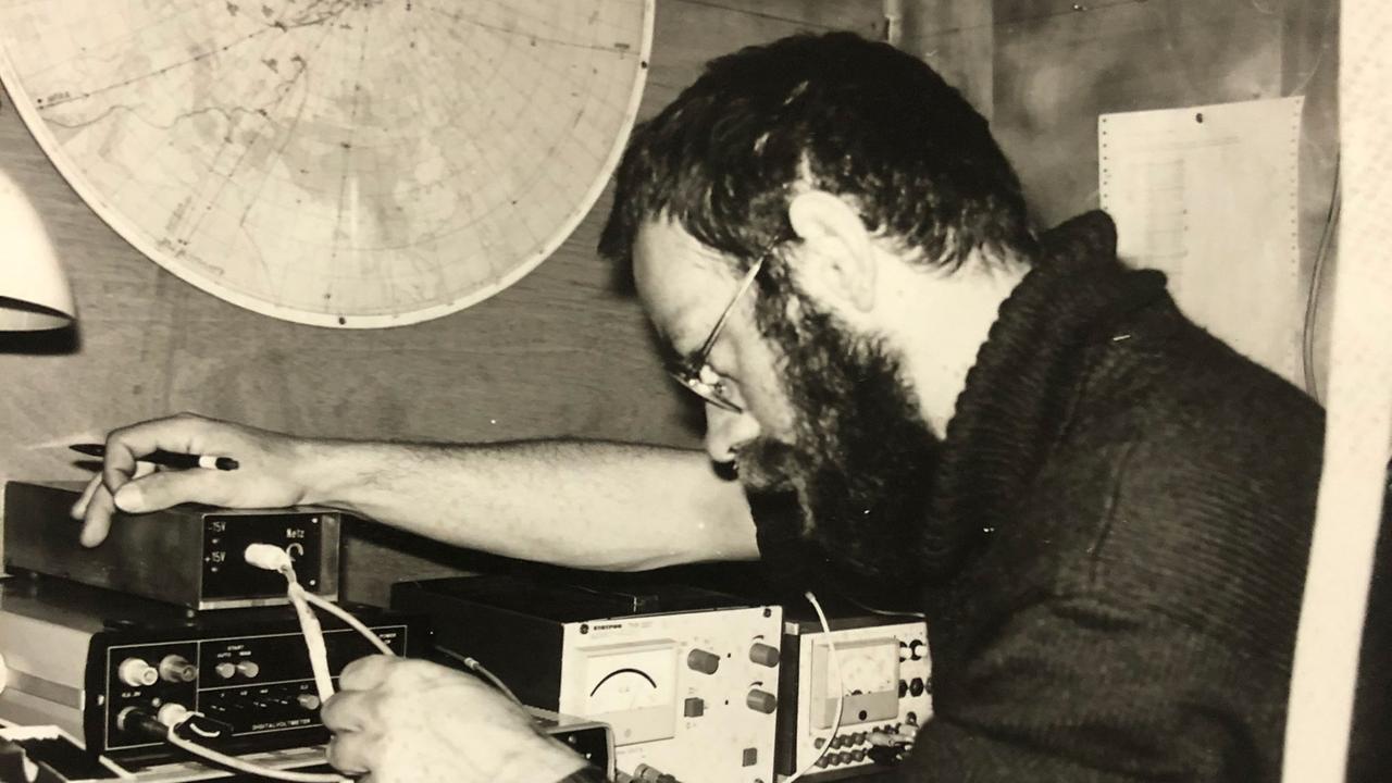 Alte Schwarzweiß-Aufnahme der bärtigen Norbert Flaake, wie er in der Station vor Geräten seine Messergebnisse auswertet.