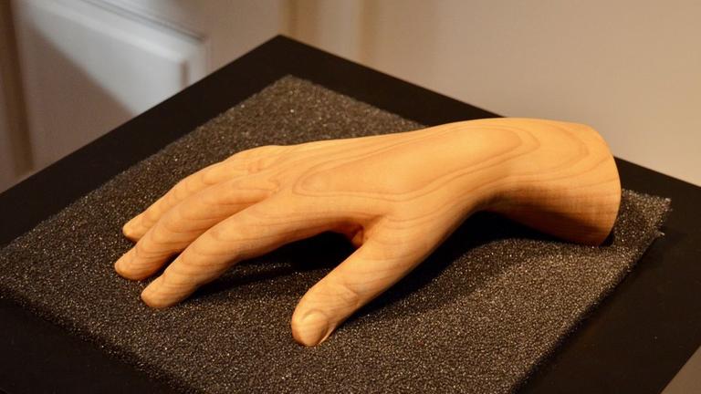 Die Hand der Pianistin Clara Schumann aus Holz liegt auf einem schwarzen Untergrund im Schumann-Haus in Leipzig.