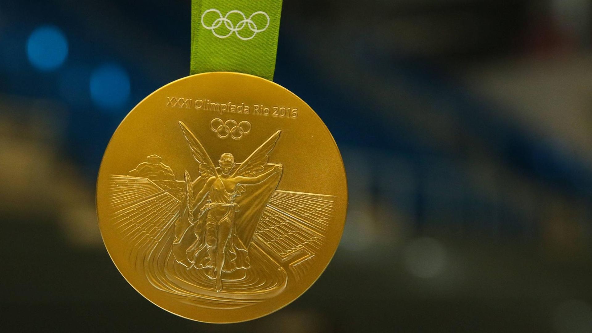 Michael Damgaard (SC Magdeburg) zeigt seine olympische Goldmedaille von Rio.