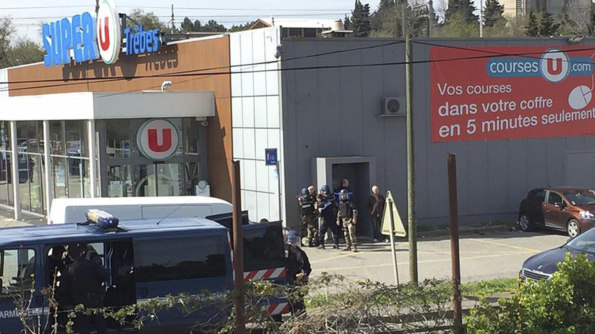 Polizisten stehen in dem Ort Trèbes am Rande von Carcassonne an einer Seitentür eines Supermarktes, in dem ein Mann Geiseln genommen hat.