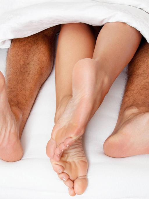 Die Füße eines Paares im Bett