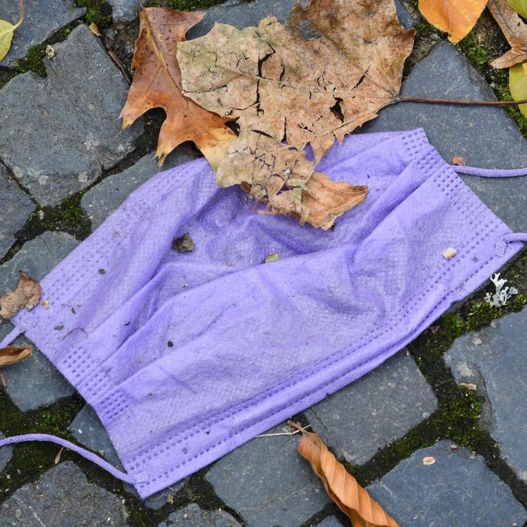 Eine weggeworfene Mundschutzmaske in Freiburg. Die Fallzahlen steigen, eine verschärfte Maskenpflicht ist vielerorts bei steigender 7-Tage-Inzidenz angeordnet.