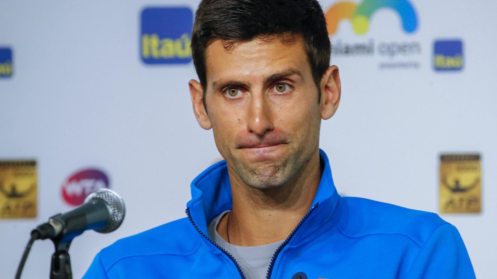 Man sieht den Tennisspieler Novak Djokovic hinter einem Mikrofon.