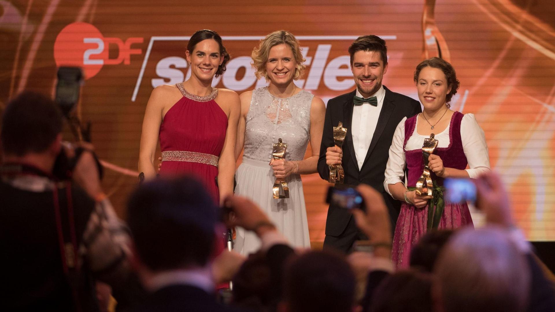 Die Beach-Volleyballerinnen Kira Walkenhorst und Laura Ludwig, der Nordische Kombinierer Johannes Rydzek und die Biathletin Laura Dahlmeier stehen mit ihren Preisen vor den Fotografen.