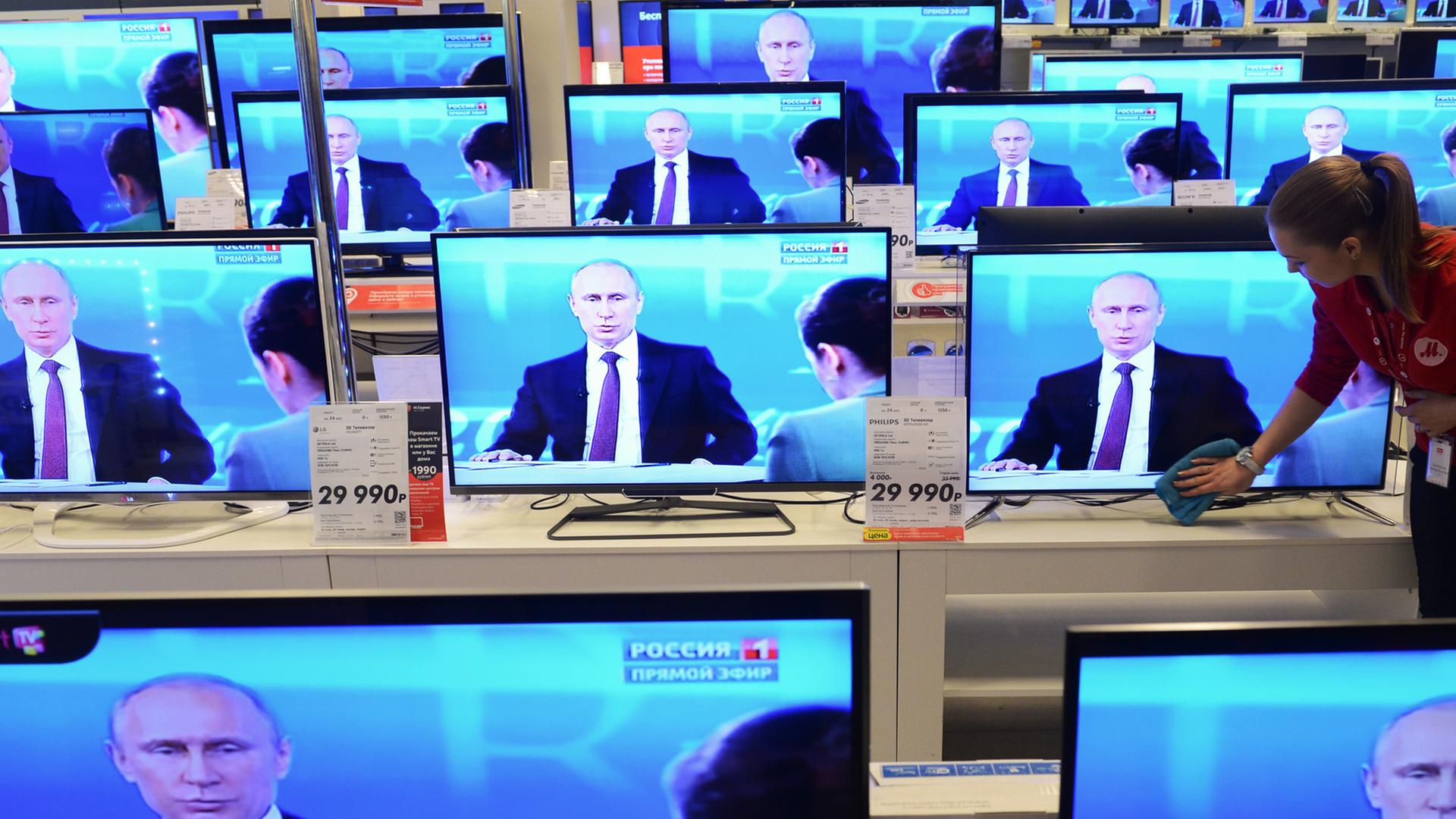 Der russische Präsiden stellt sich im Staatsfernsehen Bürgerfragen und ist auf vielen Bildschirmen in einem TV-Geschäft zu sehen. 
