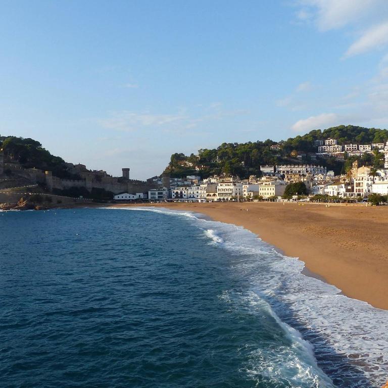 Blick auf Strand, Meer und Felsenküste bei Tossa de Mar an der Costa Brava in Spanien.