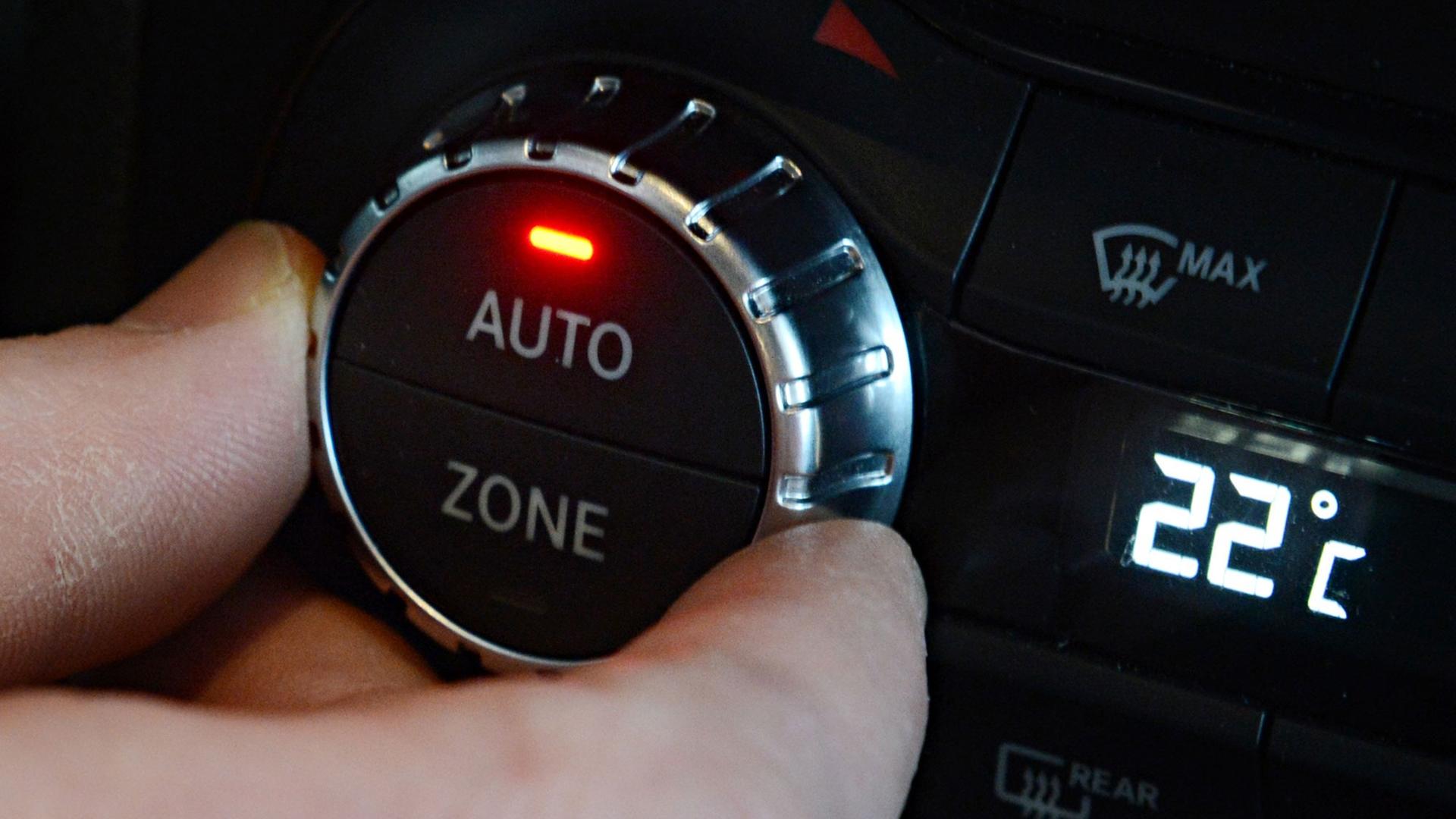 Eine Hand dreht in einem Daimler Erprobungsfahrzeug an einem Einstellrad einer Klimaanlage.