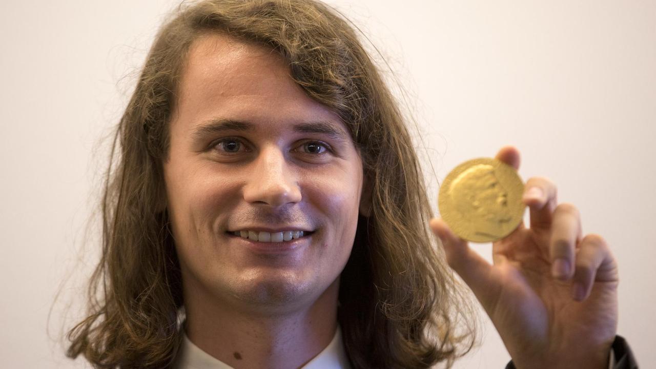 Der deutsche Mathematikprofessor Peter Scholze zeigt seine Fields-Medaille.