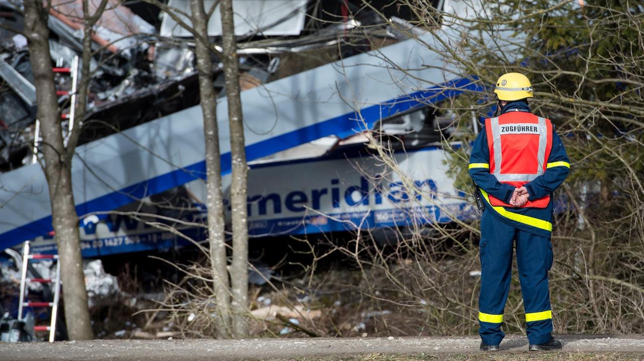 Ein Feuerwehrmann steht am Unglücksort des Zugunfalls von Bad Aibling.