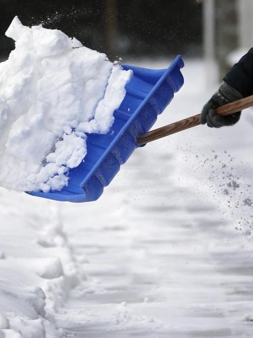 Mit einer Schneeschaufel befreit am 11.03.2013 in Berlin eine Anwohnerin den Gehsteig von der frisch gefallenen weißen Pracht. Nach Angaben der Meteorologen wird sich der Wintereinbruch auch in den kommenden Tagen mit weiteren Schneefällen und kalten Temperatuten fortsetzen.