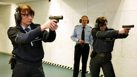 Zwei Polizistinnen aus Mettmann trainieren unter der Aufsicht eines Ausbilders das Schießen