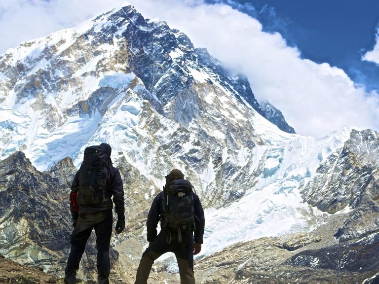 Zwei Bergsteiger blicken auf den Ama Dablam im Himalaya.