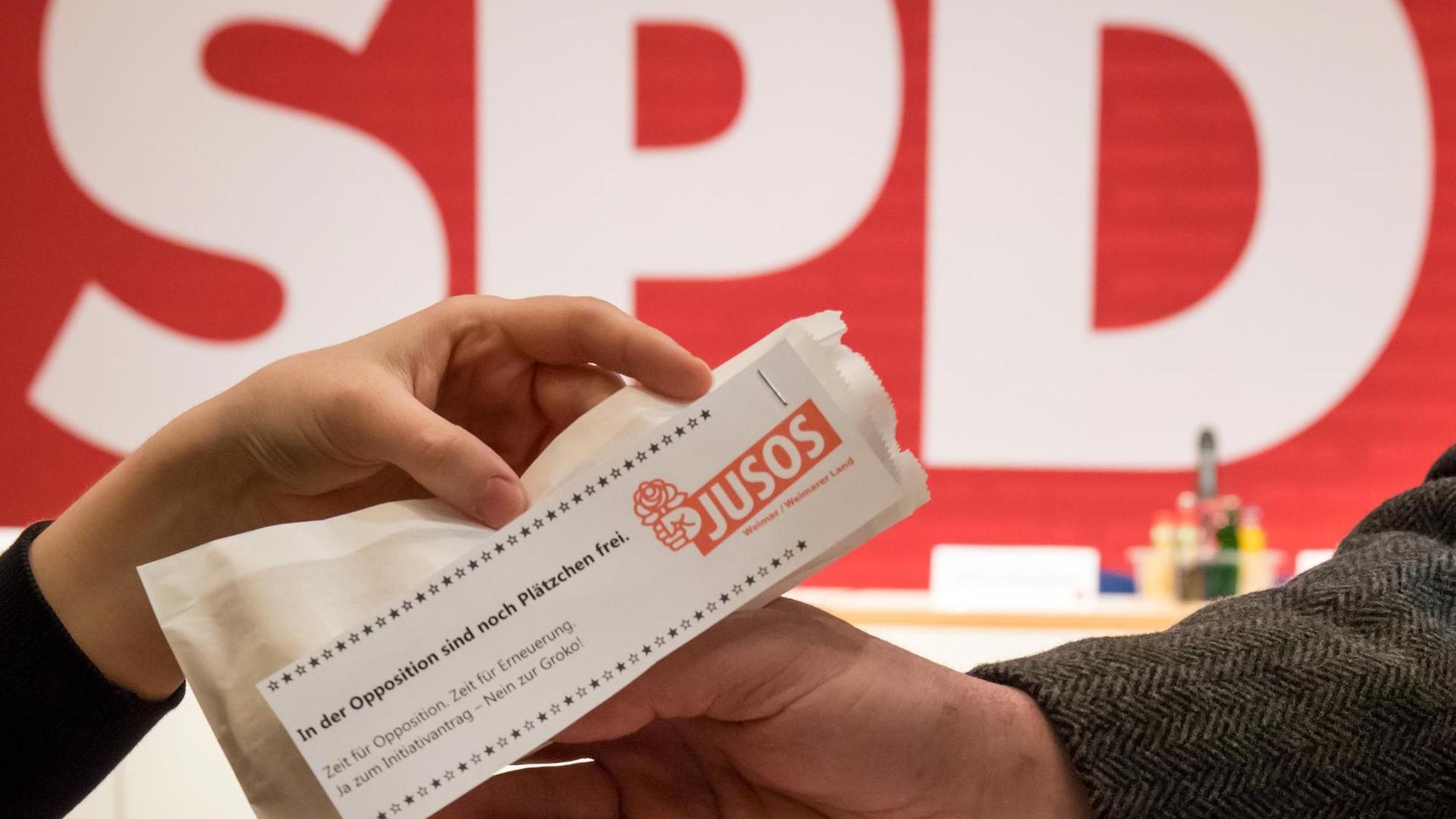 Ein Juso-Mitglied verteilt am 16.12.2017 beim außerordentlichen Landesparteitag der SPD Thüringen in Erfurt (Thüringen) eine Plätzchentüte mit Werbung für den Gang in die Opposition.
