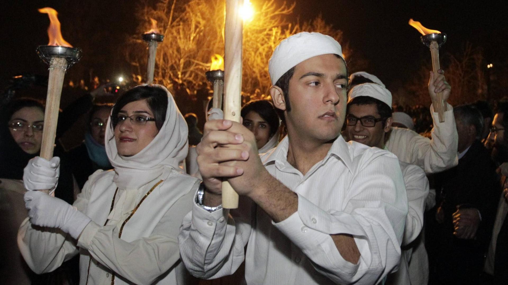 Zoroastrier tragen anlässlich des mittwinterlichen Sadeh-Fests Fackeln durch das iranische Shahriyar. Feuer gilt in der Religion als Medium der Götterverehrung.