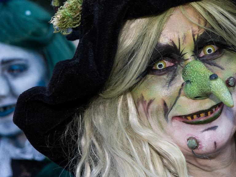 Zwei Frauen mit Hexenmasken blicken wild in die Kamera
