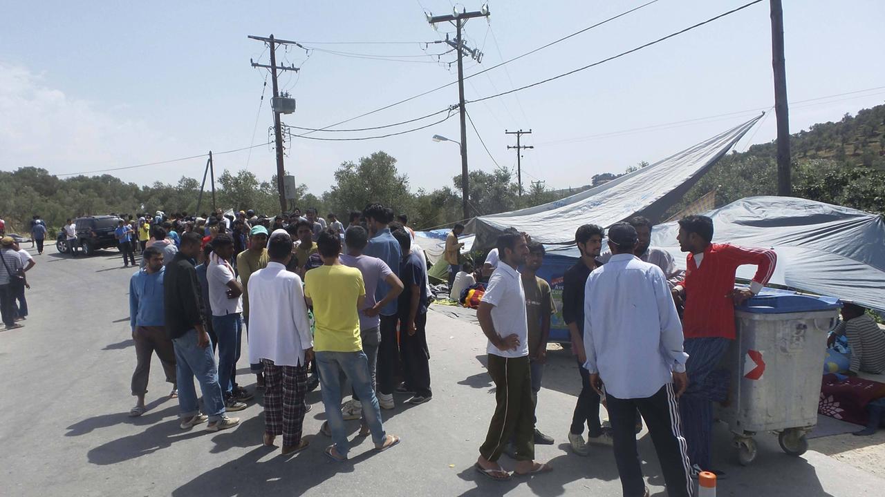 Männer stehen auf einer Straße am Flüchtlingslager Moria auf der griechischen Insel Lesbos.