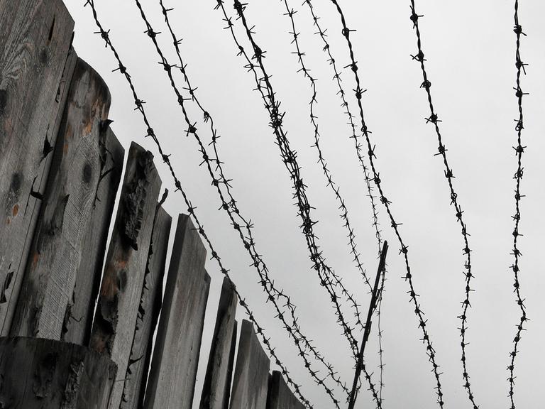 Holzbretterzaun und Stacheldraht an einem ehemaligen sowjetischen Straflager 