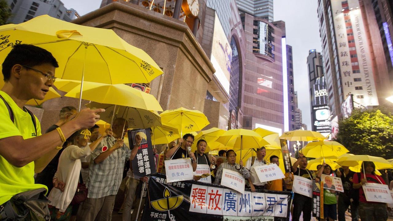 Unterstützer von Oppositionellen protestieren mit gelben Schirmen in Hongkong gegen deren Verhaftung