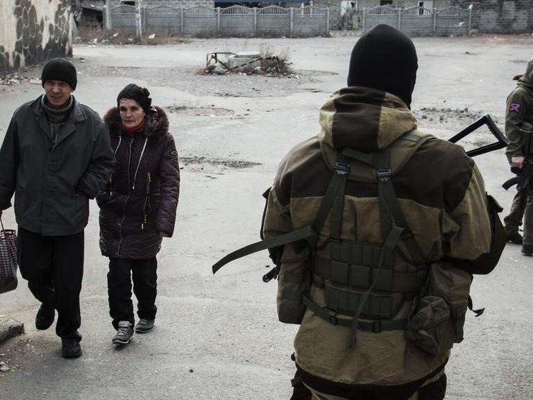 Ein Kämpfer der prorussischen Separatisten geht in der Provinz Donezk über einen zerstörten Marktplatz.