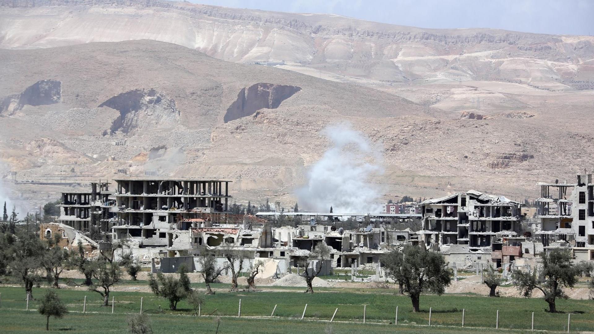 Blick auf die Stadt Douma: zerstörte Betonhäuser vor einer kahlen Landschaft