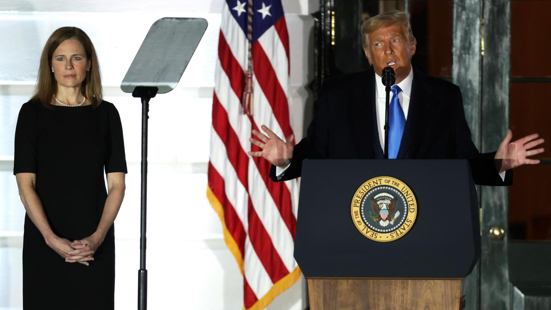 US-Präsident Donald Trump spricht, während Amy Coney Barrett, Associate Justice am Obersten Gerichtshof der USA, während einer feierlichen Vereidigung auf dem South Lawn des Weißen Hauses am 26. Oktober 2020 in Washington, DC, zuhört.
