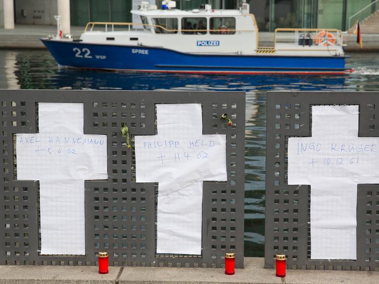 Anstelle der entfernten Gedenkkreuze sind Kreuze aus Papier am Spreeufer in Berlin angebracht. Eine Gruppe von Flüchtlings-Aktivisten hatte die sieben weißen Gedenkkreuze für die Mauertoten am Spreeufer neben dem Reichstag entfernt; Aufnahme vom 5. November 2014