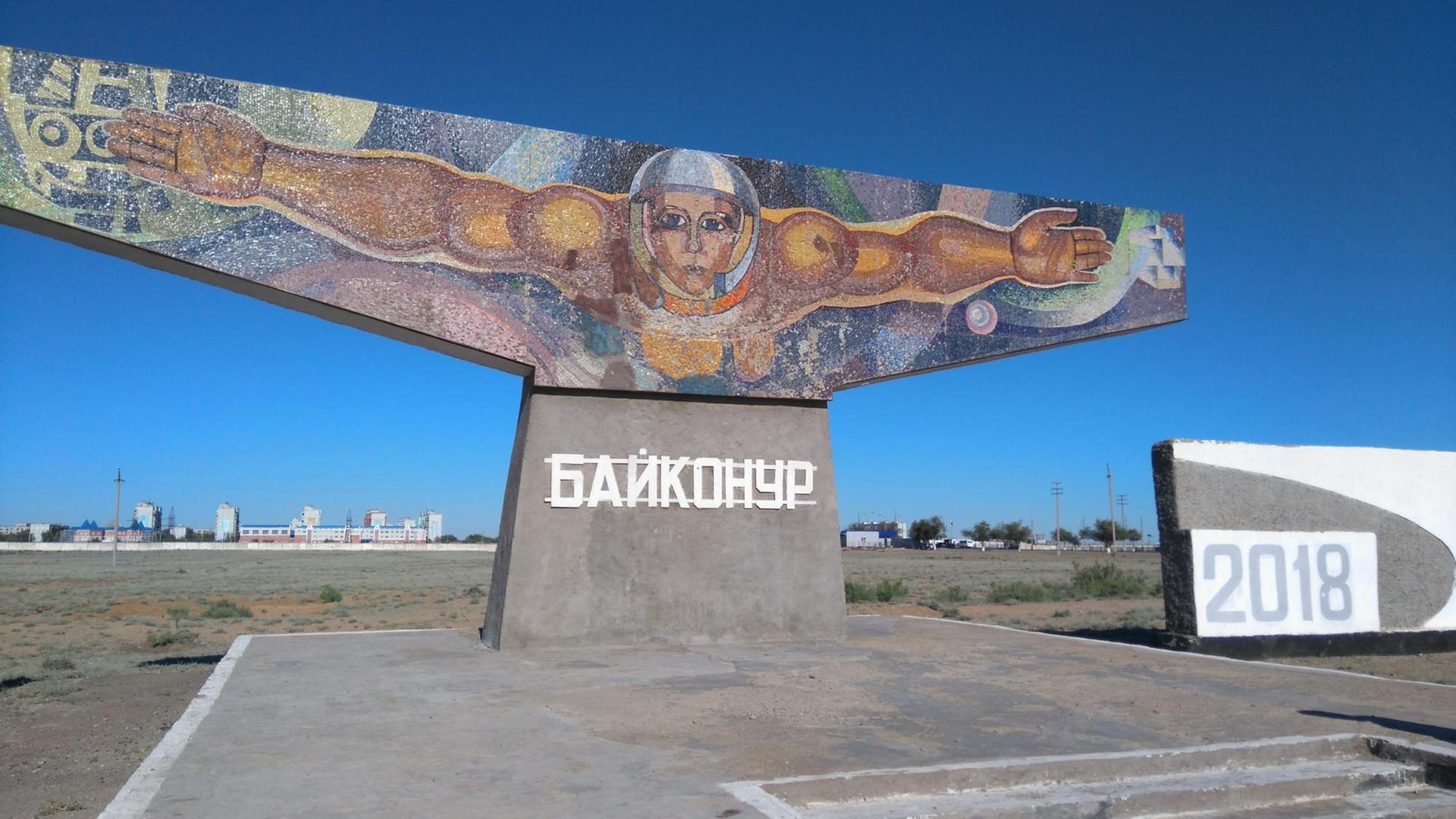 Das Monument "Der Fischer" am Eingang von Baikonur zeigt einen Mann mit ausgebreiteten Armen und Helm, der scheinbar im Weltraum schwebt, Das Monument "Der Fischer" am Eingang von Baikonur zeigt einen Mann mit ausgebreiteten Armen und Helm, der scheinbar im Weltraum schwebt,
