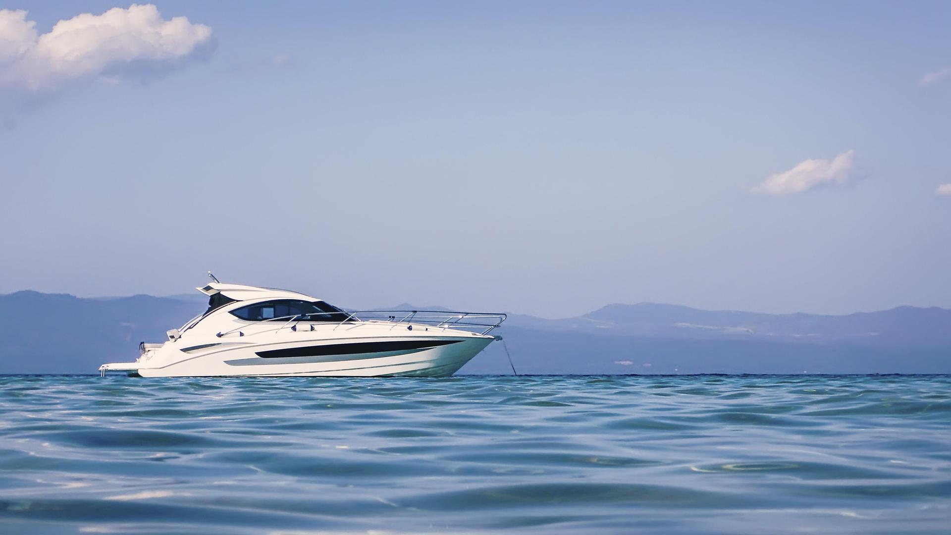 Motorboot schwimmt auf klarem türkisfarbenem Wasser Motorboot schwimmt auf klarem türkisfarbenem Wasser