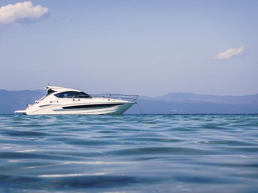 Motorboot schwimmt auf klarem türkisfarbenem Wasser Motorboot schwimmt auf klarem türkisfarbenem Wasser