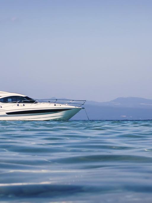 Motorboot schwimmt auf klarem türkisfarbenem Wasser Motorboot schwimmt auf klarem türkisfarbenem Wasser