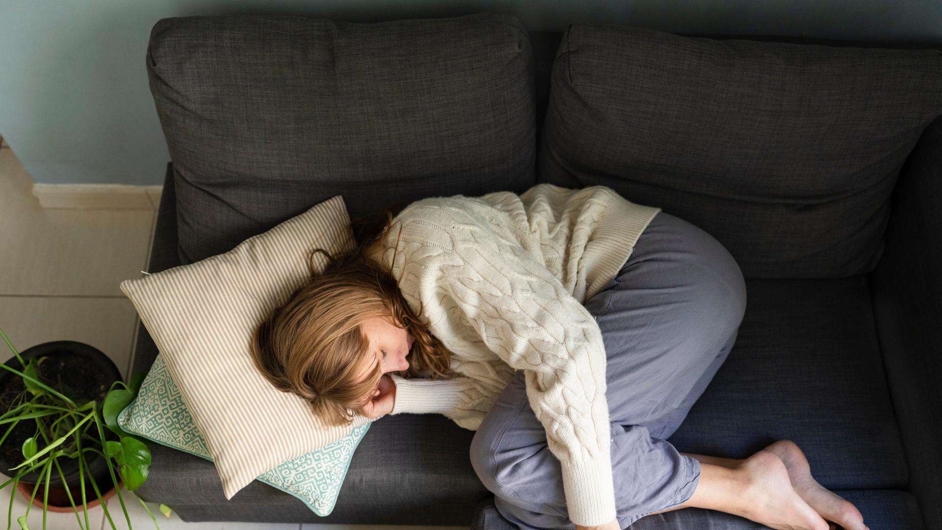 Eine Frau liegt schlafend auf dem Sofa Eine Frau liegt schlafend auf dem Sofa